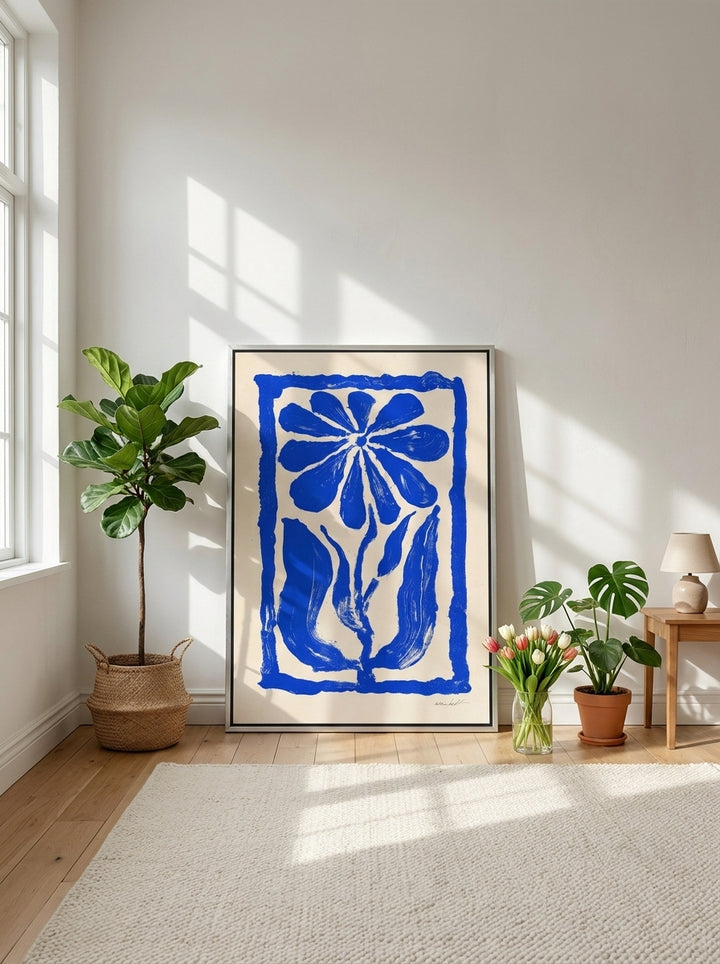 Canvas wall art with a silver leaf surround leaning against the wall in a bright Scandinavian bedroom