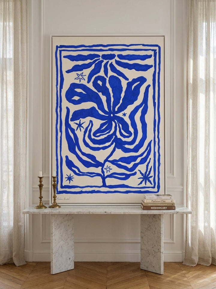 Canvas wall art with a white surround standing on a console in a Parisian bedroom