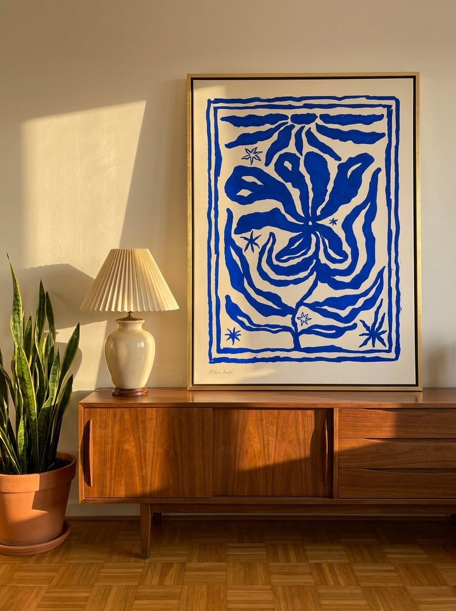 Canvas wall art with a gold leaf surround standing on a sideboard in a mid-century home office