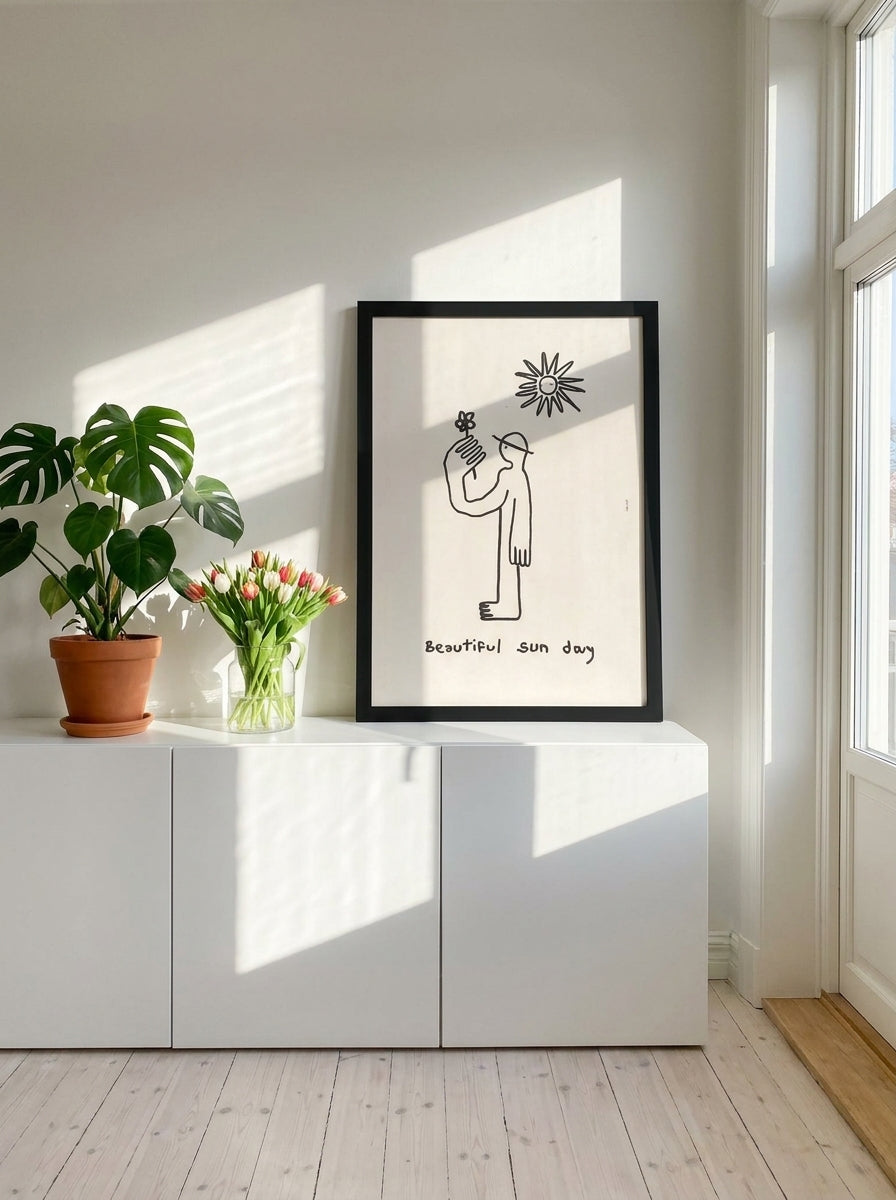 Modern wall art print standing on a sideboard in a bright Scandinavian bedroom