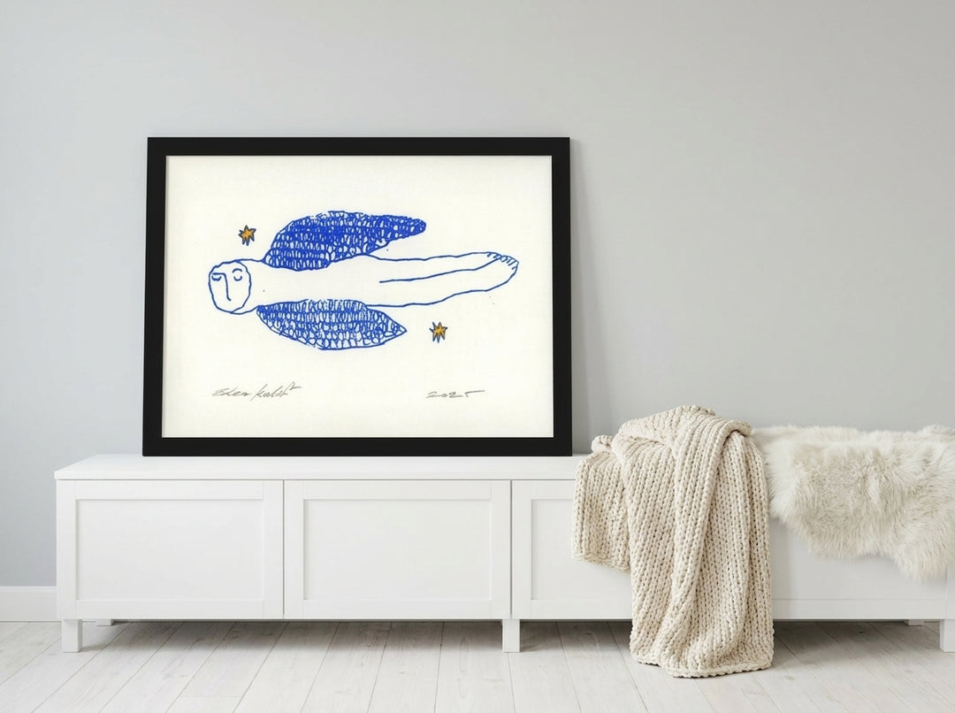 Modern wall art print standing on a sideboard in a bright Scandinavian bedroom