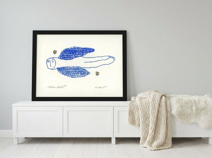 Modern wall art print standing on a sideboard in a bright Scandinavian bedroom