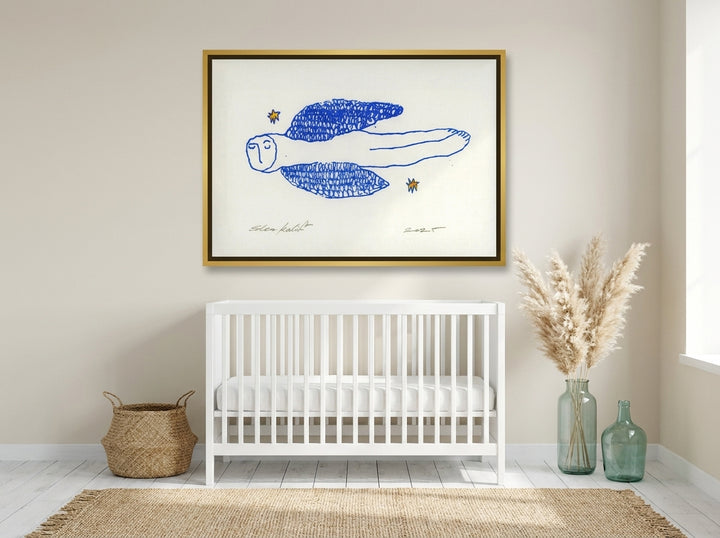 Canvas wall art with a gold leaf surround styled on the wall in a coastal nursery