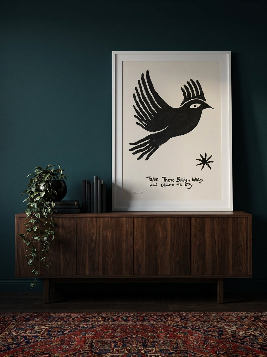 Modern wall art print standing on a sideboard in a moody home office