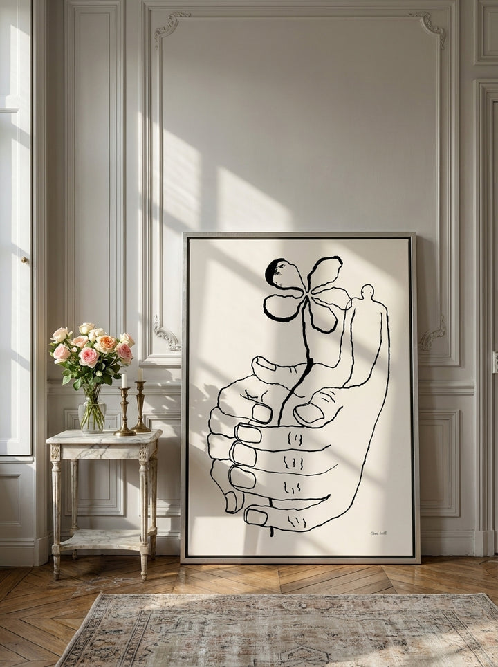 Canvas wall art with a silver leaf surround leaning against the wall in a Parisian bathroom