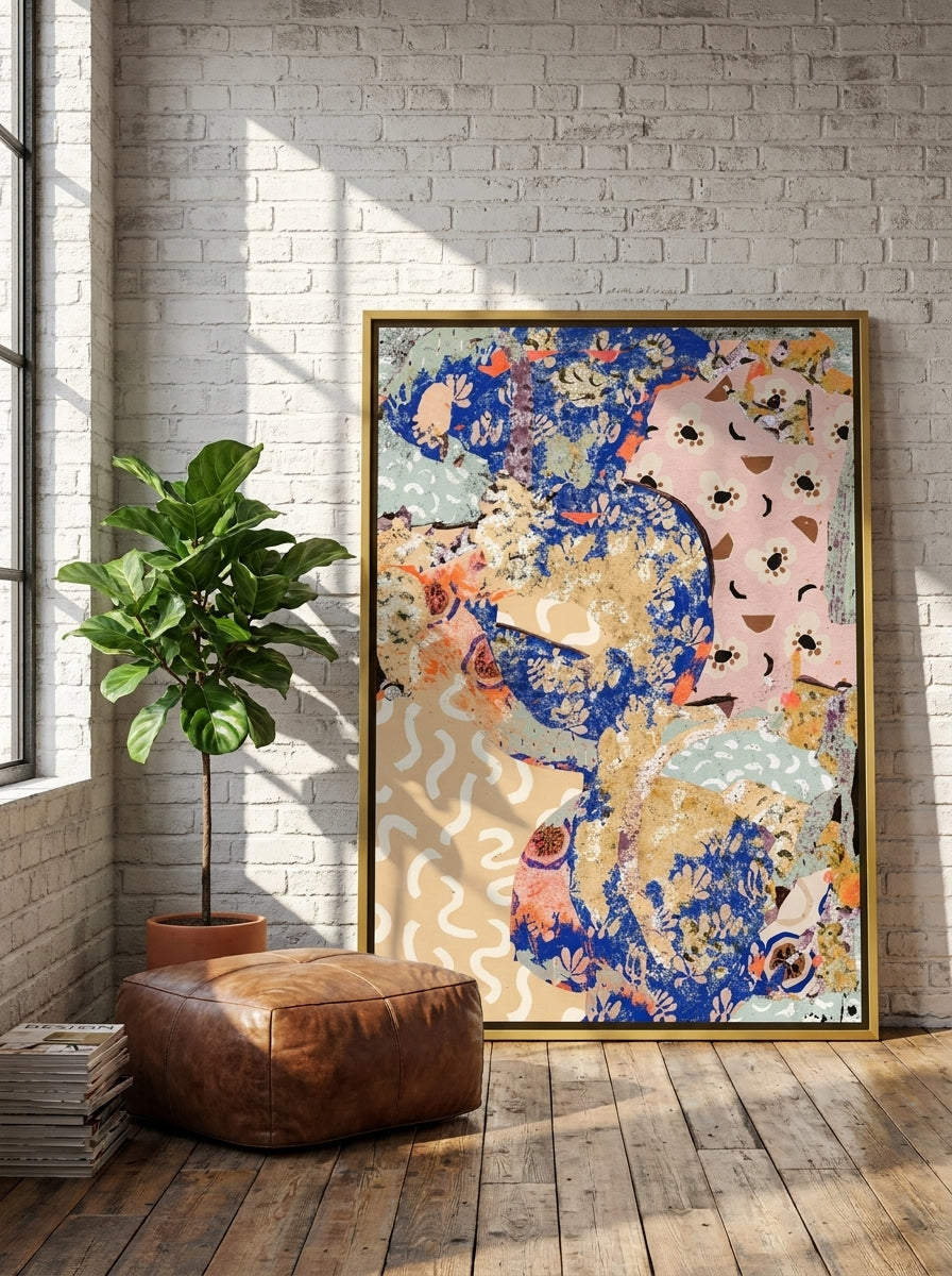 Oversized statement canvas wall art with a gold leaf surround leaning against the wall in an industrial loft living room