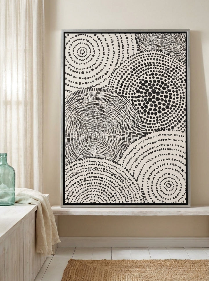 Canvas wall art with a silver leaf surround standing on a console in a coastal home office