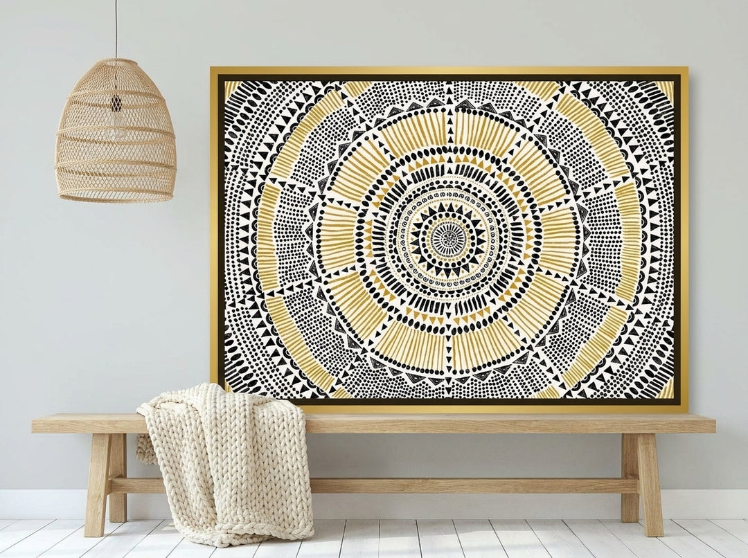 Canvas wall art with a gold leaf surround standing on a bench in a bright Scandinavian living room