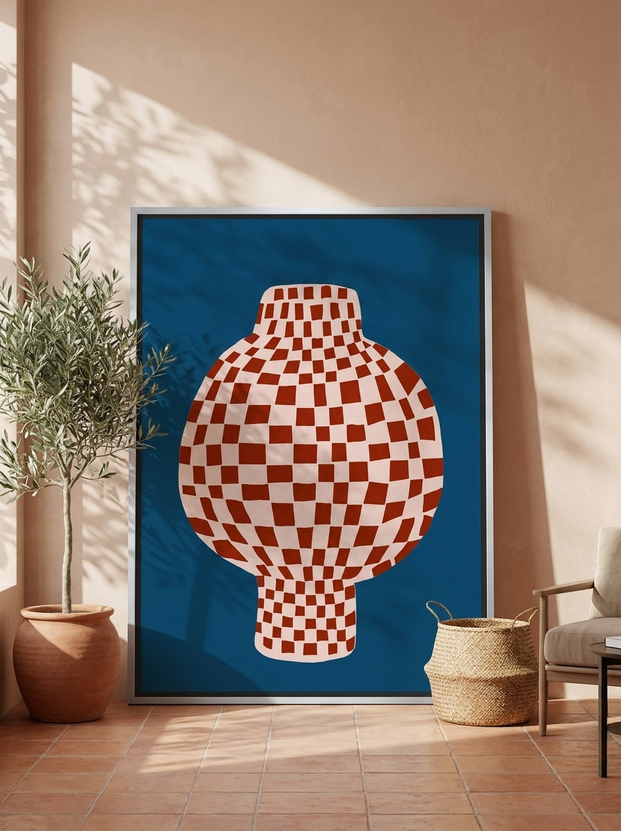 Oversized statement canvas wall art with a silver leaf surround leaning against the wall in a Mediterranean dining room