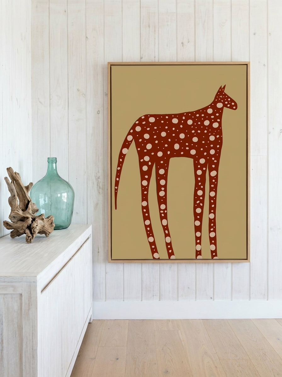 Canvas wall art with a natural timber surround standing on a console in a coastal bedroom