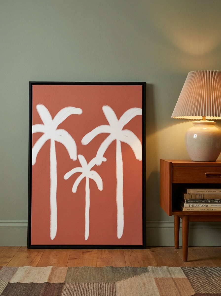 Canvas wall art with a black surround leaning against the wall in a mid-century dining room