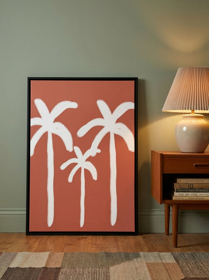 Canvas wall art with a black surround leaning against the wall in a mid-century dining room