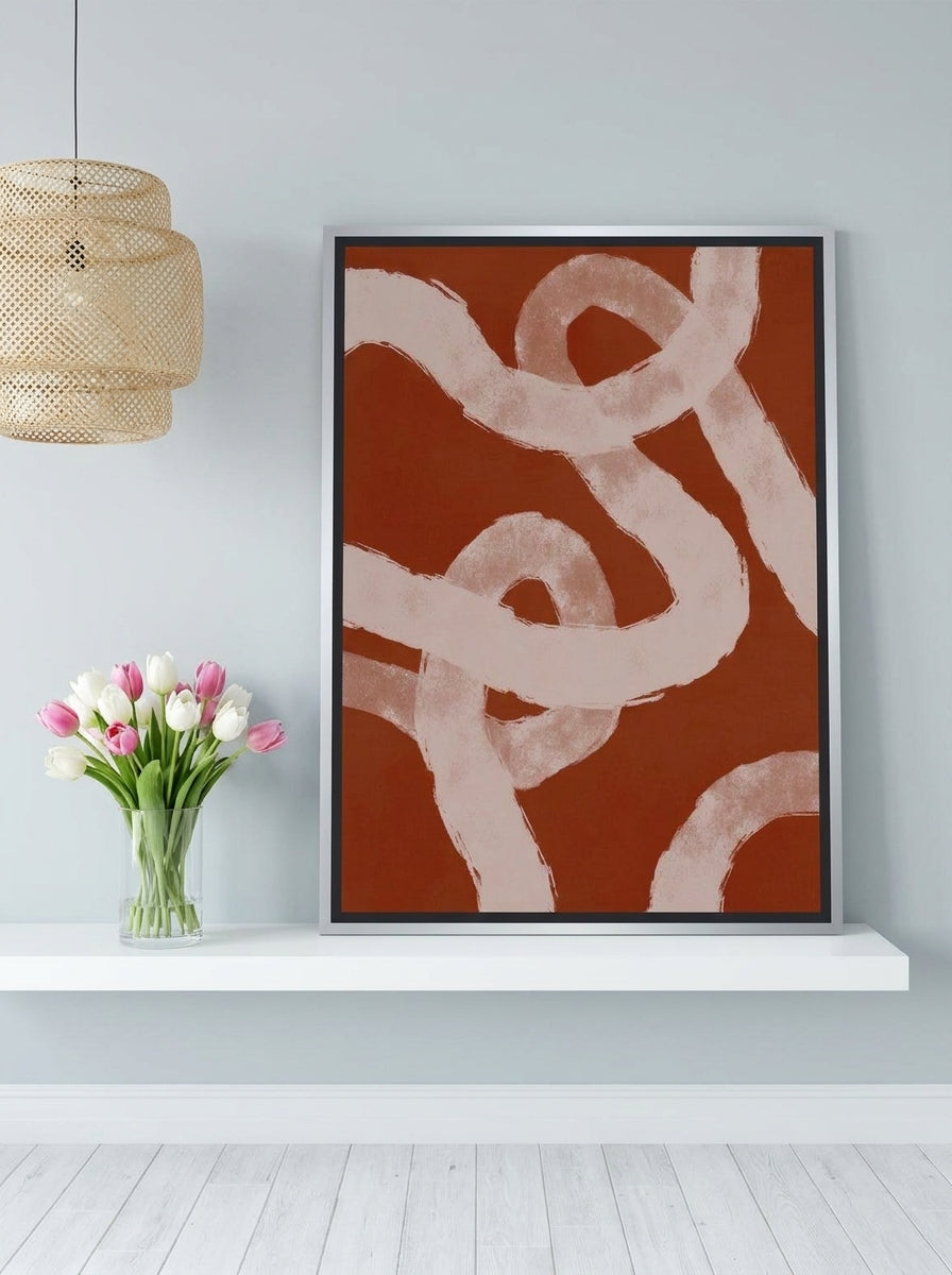 Canvas wall art with a silver leaf surround standing on a shelf in a bright Scandinavian bedroom