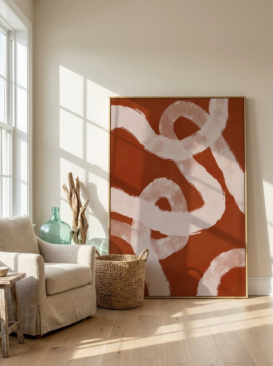 Oversized statement canvas wall art with a gold leaf surround leaning against the wall in a coastal living room