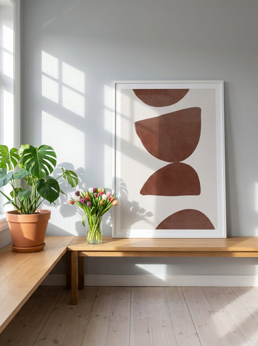 Modern wall art print standing on a bench in a bright Scandinavian home office