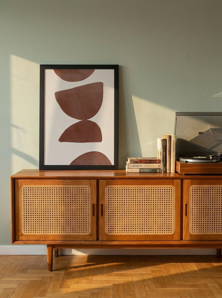Modern wall art print standing on a sideboard in a mid-century living room