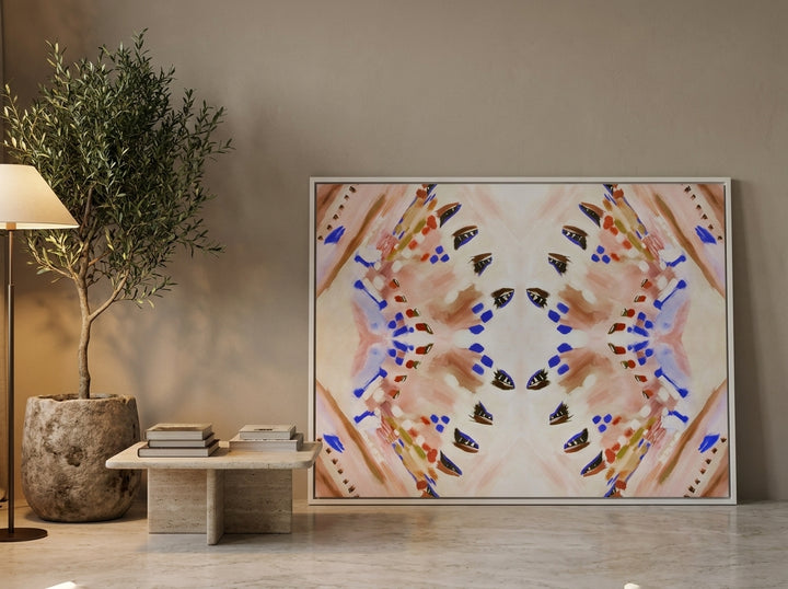 Oversized statement canvas wall art with a white surround leaning against the wall in a luxe living room
