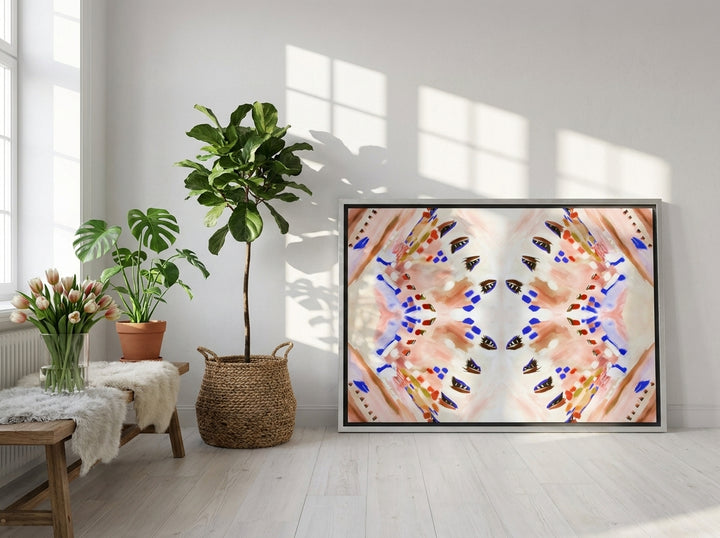 Oversized statement canvas wall art with a silver leaf surround leaning against the wall in a bright Scandinavian dining room