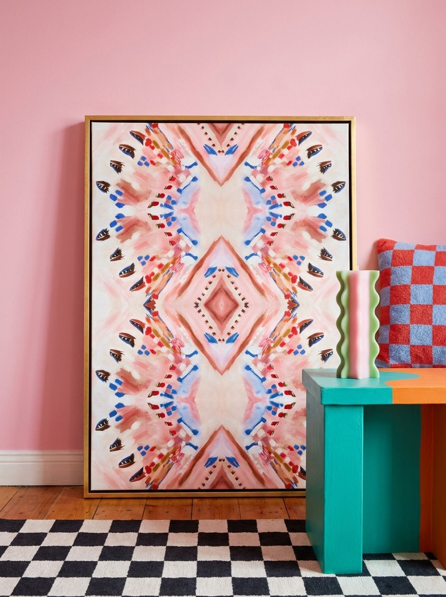 Oversized statement canvas wall art with a gold leaf surround leaning against the wall in a colourful eclectic dining room
