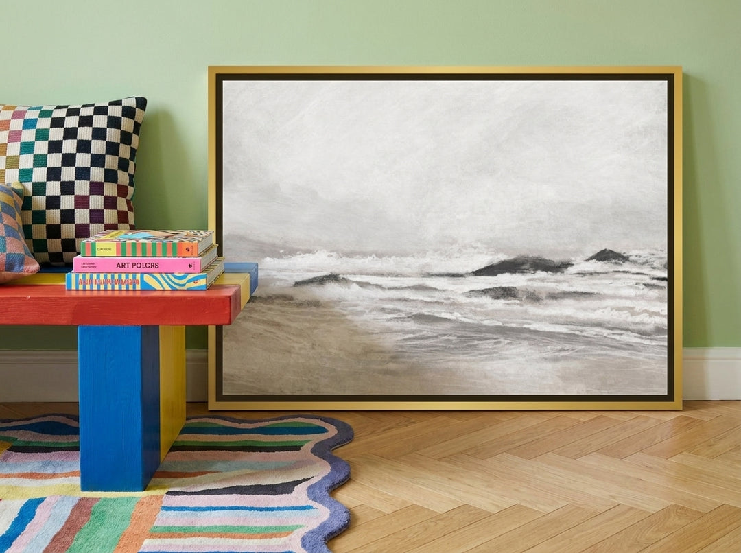 Canvas wall art with a gold leaf surround standing on a side table in a colourful eclectic living room