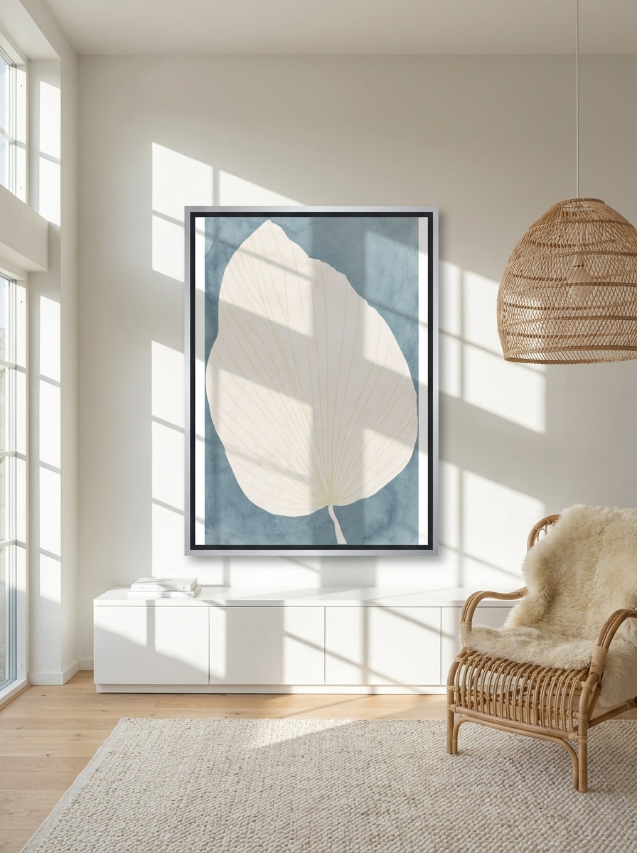 Oversized statement canvas wall art with a silver leaf surround styled on the wall in a bright Scandinavian living room