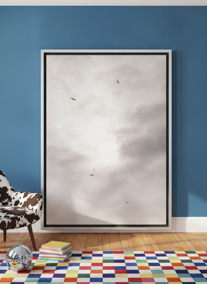 Oversized statement canvas wall art with a silver leaf surround leaning against the wall in a colourful eclectic living room