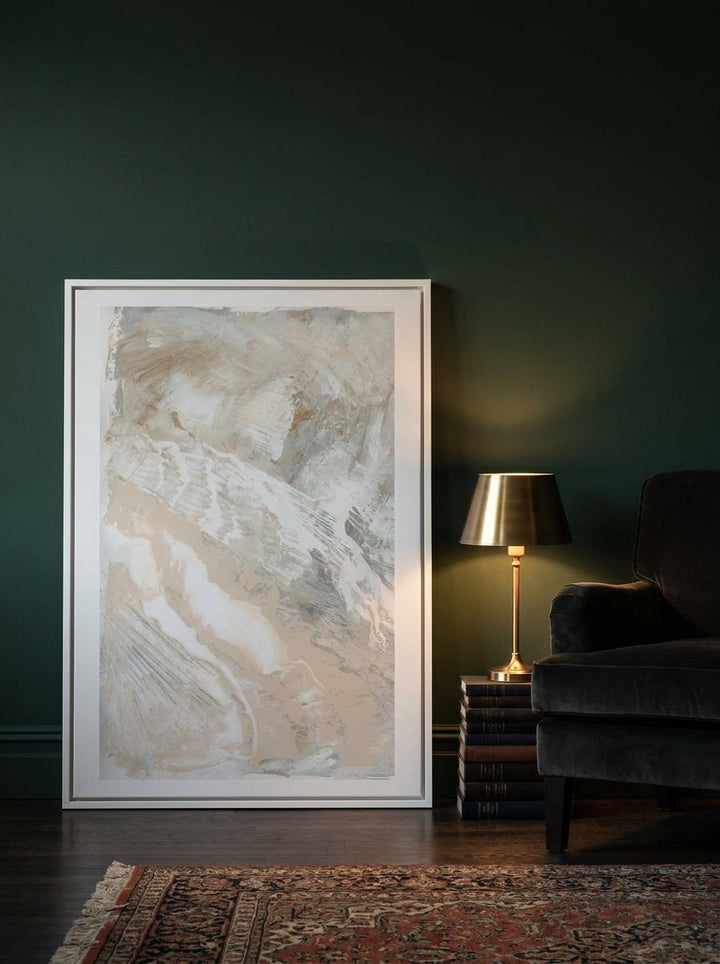 Canvas wall art with a white surround leaning against the wall in a moody bedroom