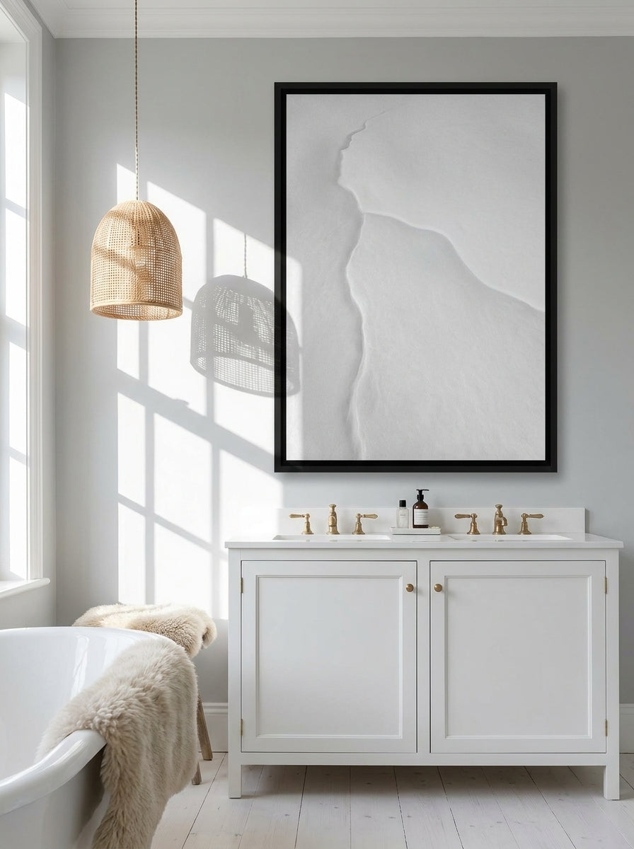 Canvas wall art with a black surround styled on the wall in a bright Scandinavian bathroom