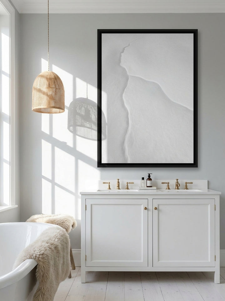 Canvas wall art with a black surround styled on the wall in a bright Scandinavian bathroom