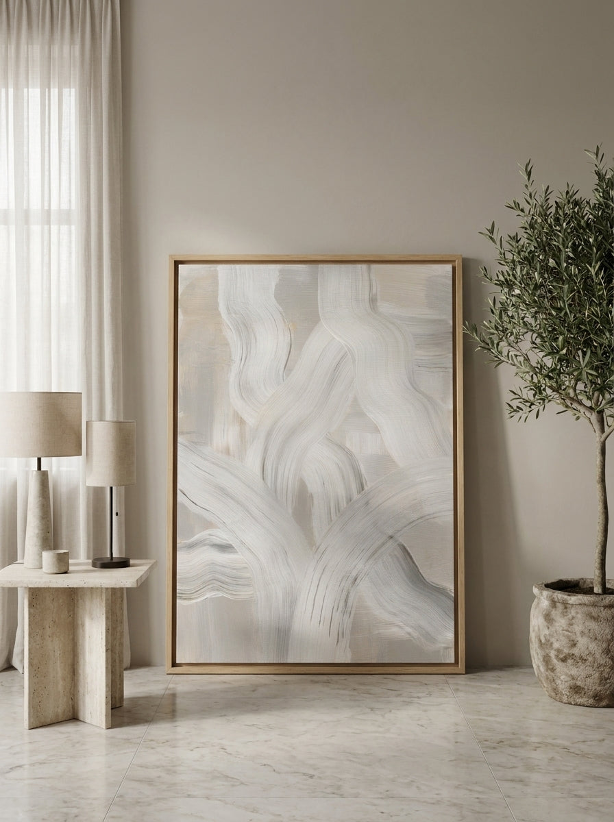 Oversized statement canvas wall art with a natural timber surround leaning against the wall in a luxe living room