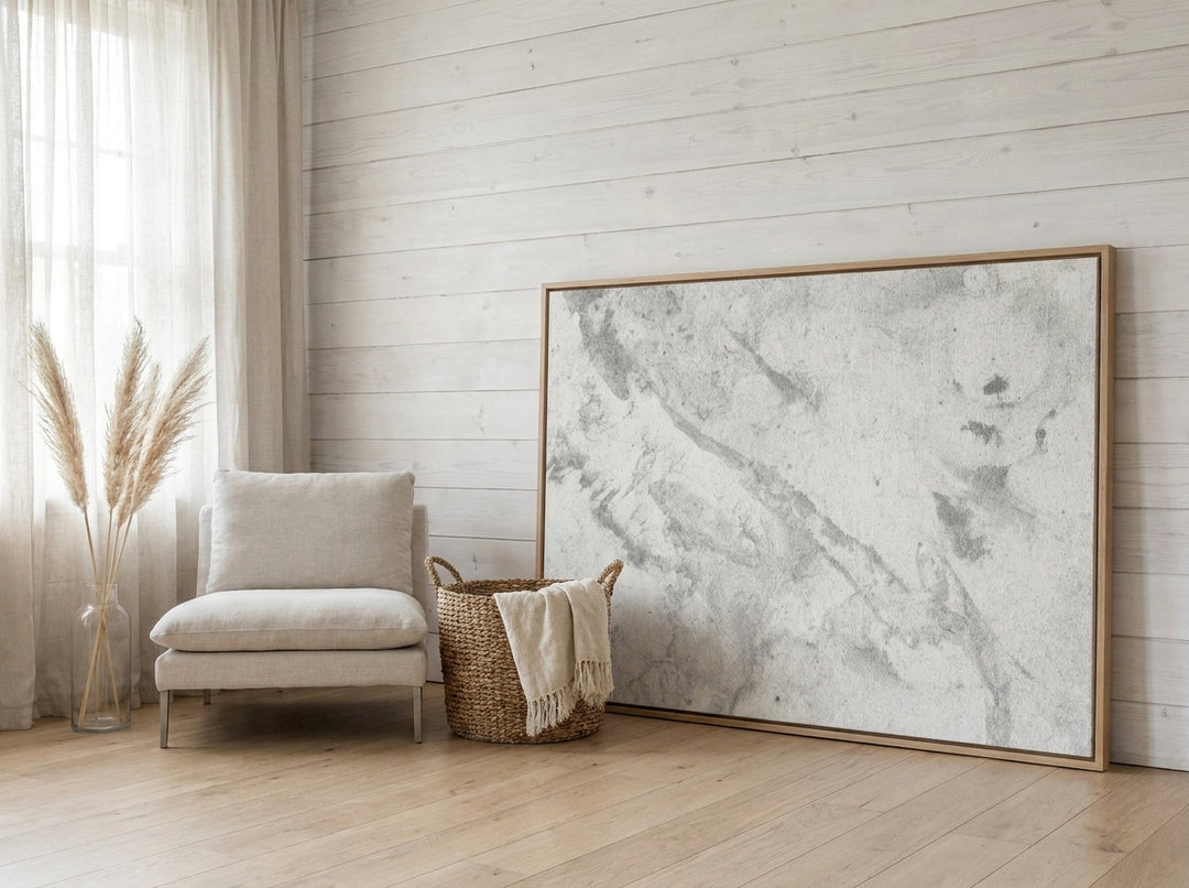 Oversized statement canvas wall art with a natural timber surround leaning against the wall in a coastal home office