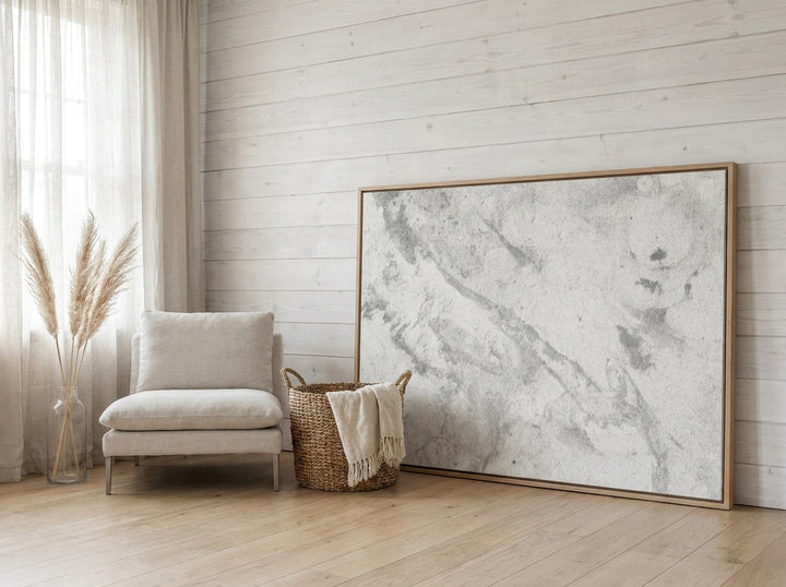 Oversized statement canvas wall art with a natural timber surround leaning against the wall in a coastal home office