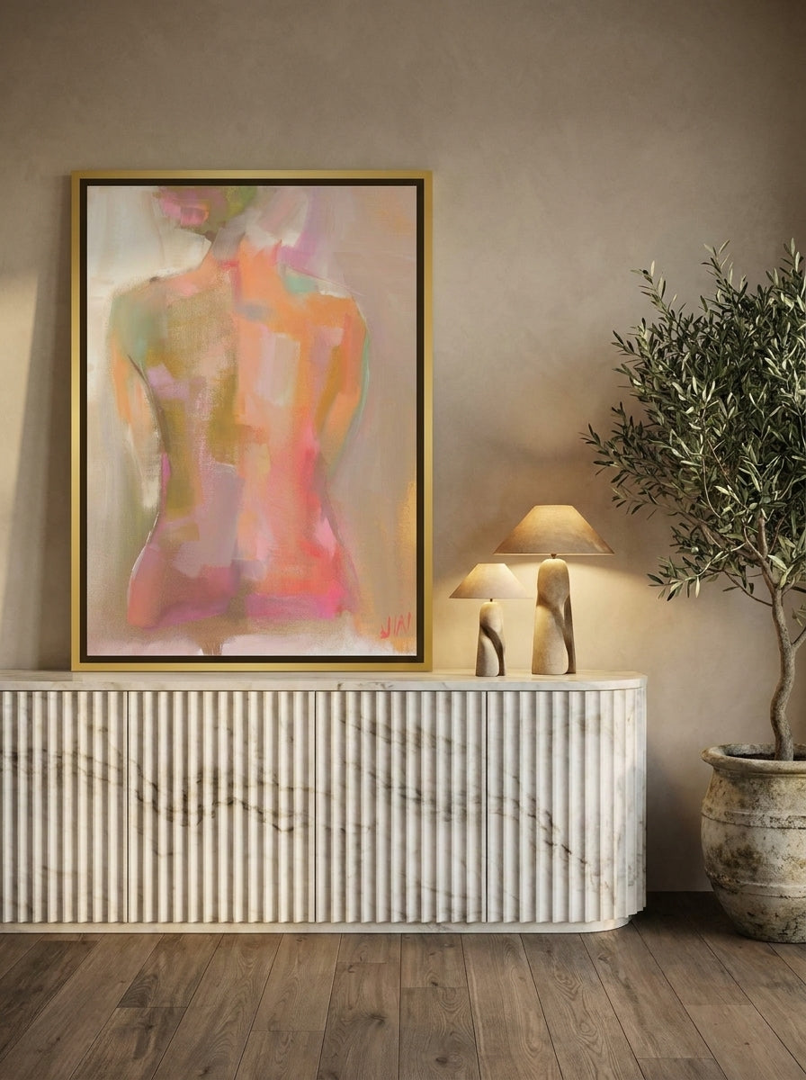 Canvas wall art with a gold leaf surround standing on a sideboard in a luxe living room