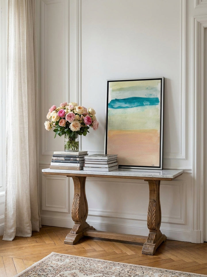 Canvas wall art with a silver leaf surround standing on a console in a Parisian bedroom