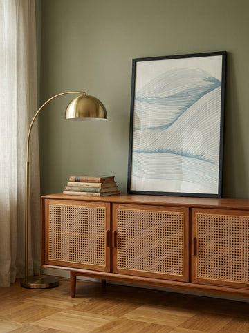 Modern wall art print standing on a sideboard in a mid-century bedroom