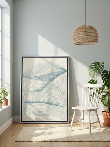 Canvas wall art with a silver leaf surround leaning against the wall in a bright Scandinavian bathroom