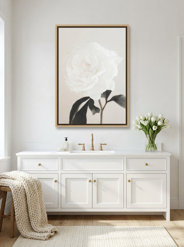 Canvas wall art with a natural timber surround styled on the wall in a bright Scandinavian bathroom
