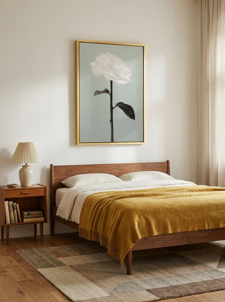 Canvas wall art with a gold leaf surround styled on the wall in a mid-century bedroom