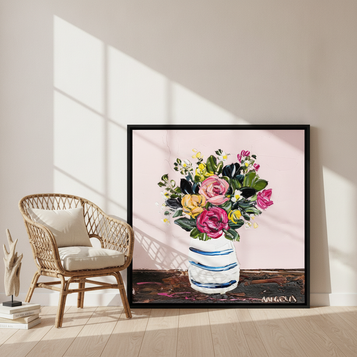 Canvas wall art with a black surround leaning against the wall in a coastal bedroom