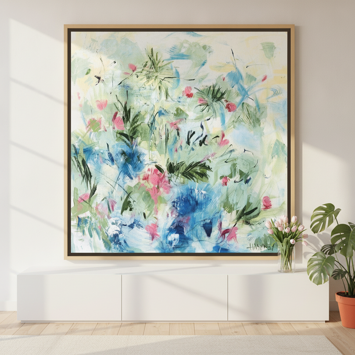 Canvas wall art with a natural timber surround standing on a sideboard in a bright Scandinavian bedroom