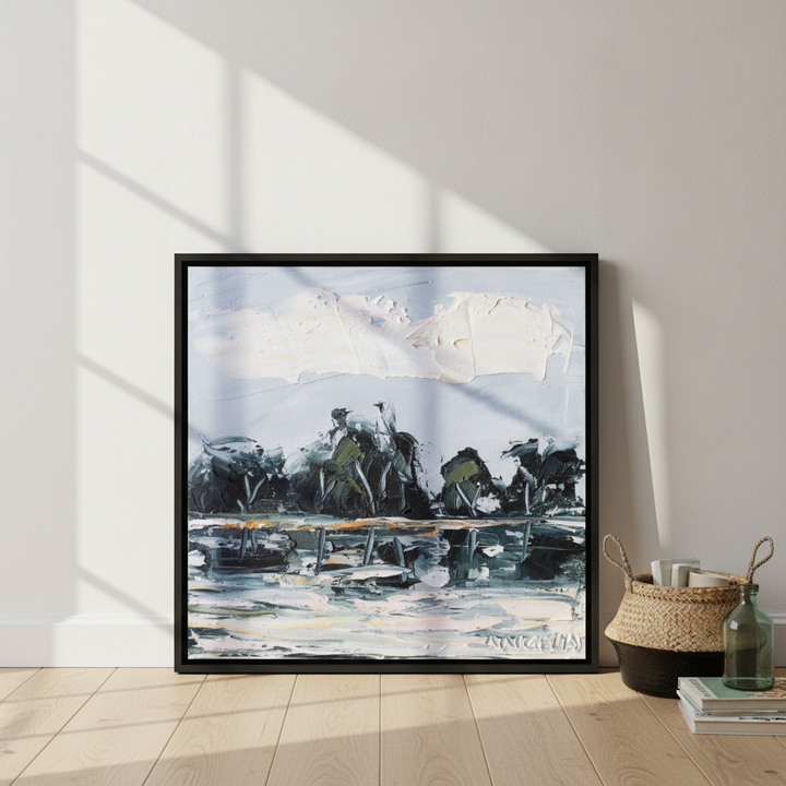 Canvas wall art with a black surround leaning against the wall in a coastal home office