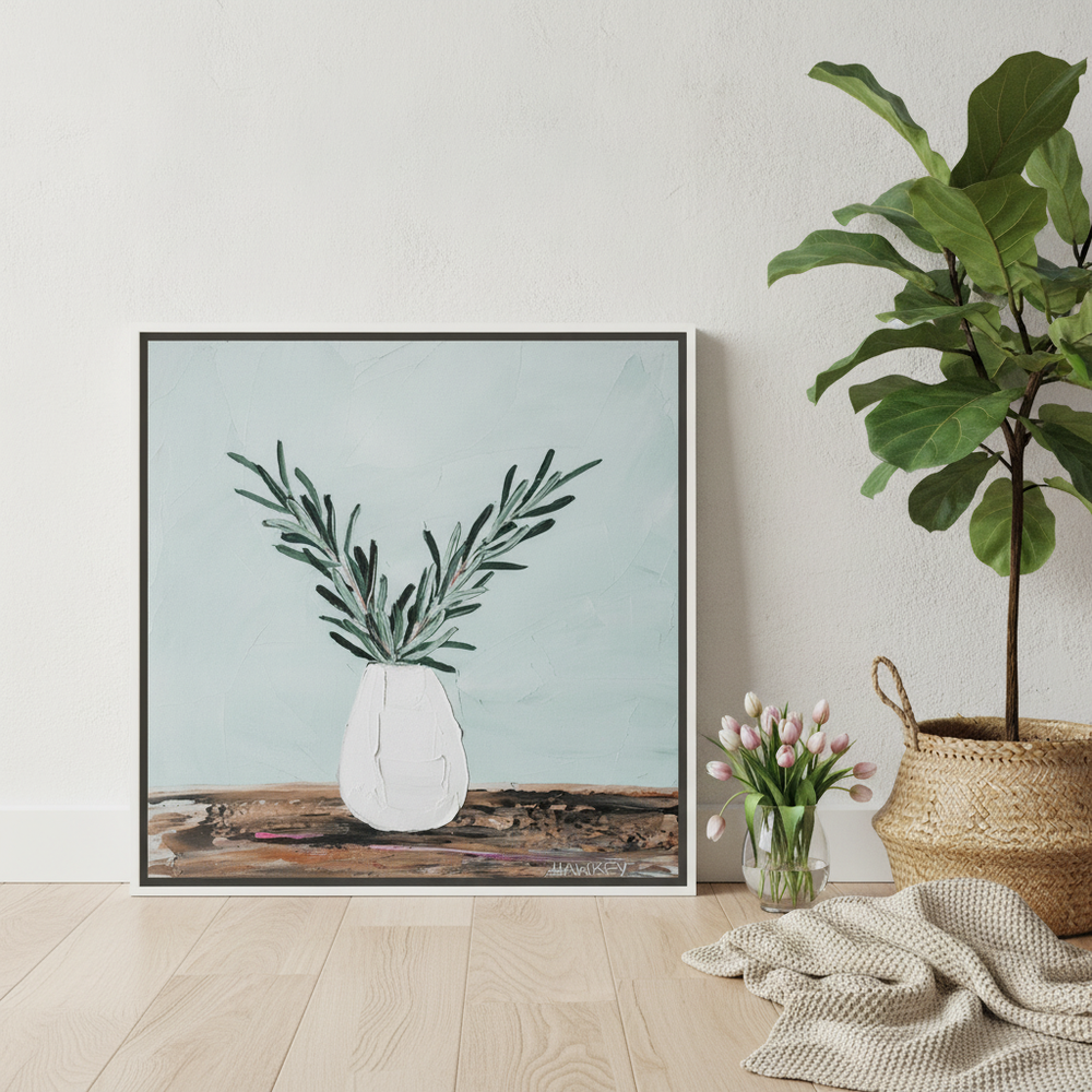 Canvas wall art with a white surround leaning against the wall in a bright Scandinavian bedroom