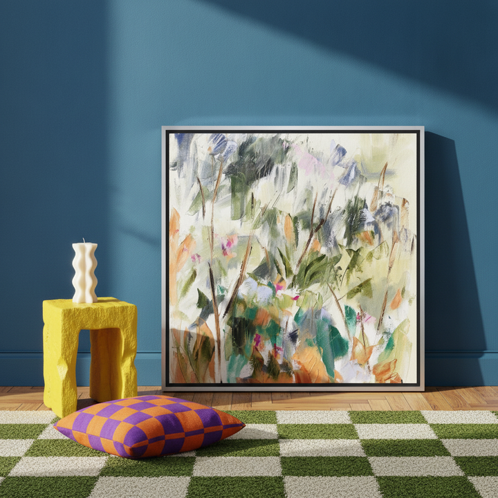 Canvas wall art with a silver leaf surround leaning against the wall in a colourful eclectic living room