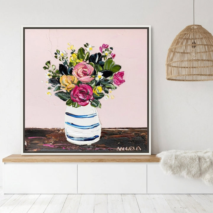 Canvas wall art with a white surround standing on a kitchen bench in a bright Scandinavian kitchen