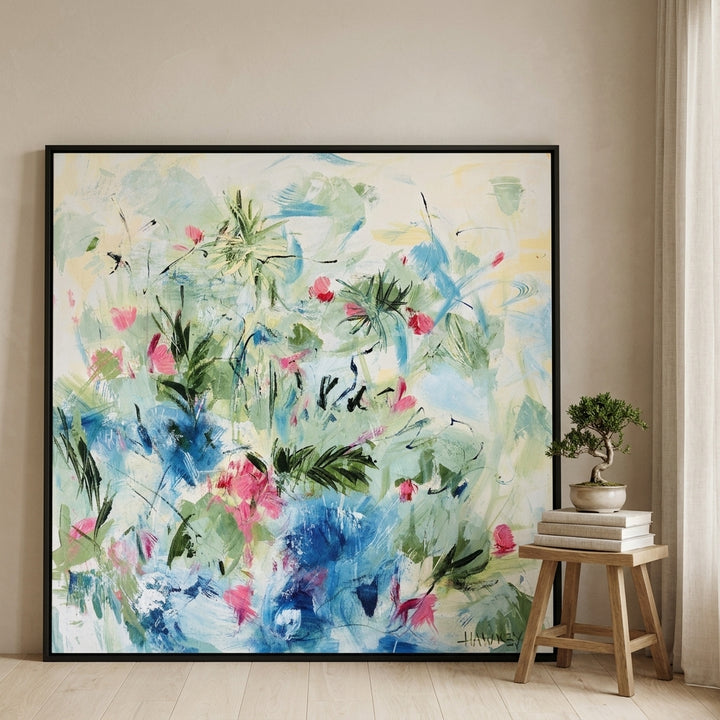 Oversized statement canvas wall art with a black surround leaning against the wall in a warm Japandi dining room