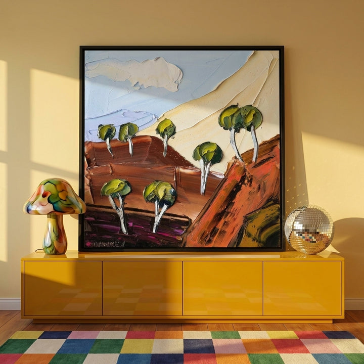 Canvas wall art with a black surround standing on a sideboard in a colourful eclectic home office