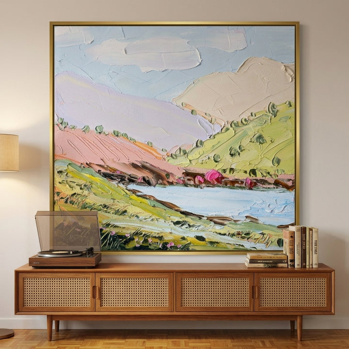 Oversized statement canvas wall art with a gold leaf surround styled on the wall in a mid-century living room