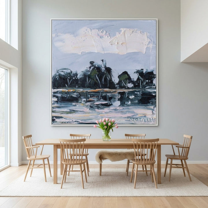 Oversized statement canvas wall art with a white surround styled on the wall in a bright Scandinavian dining room