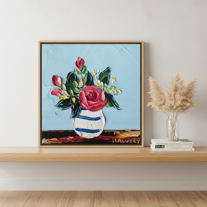 Canvas wall art with a natural timber surround standing on a kitchen bench in a coastal kitchen