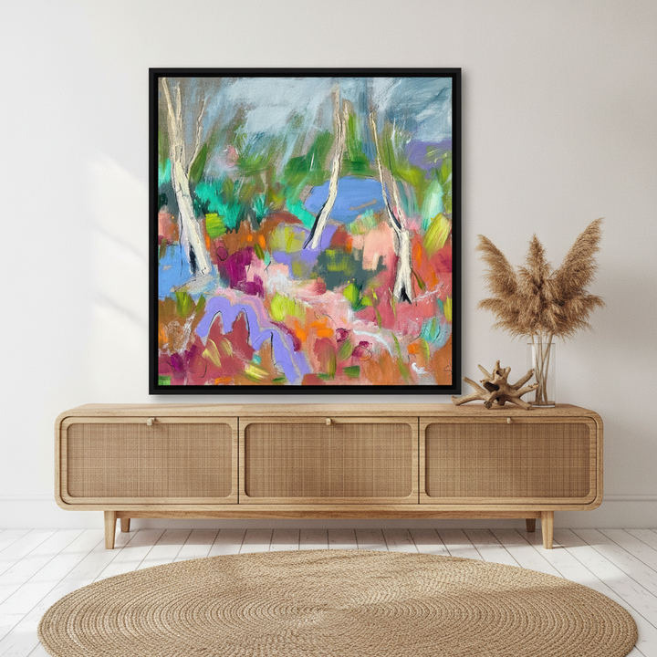 Canvas wall art with a black surround standing on a sideboard in a coastal bedroom